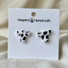 Cow print earrings on a Hayden Handcraft branded card with a beige background
