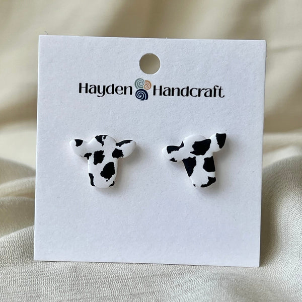 Cow print earrings on a Hayden Handcraft branded card with a beige background